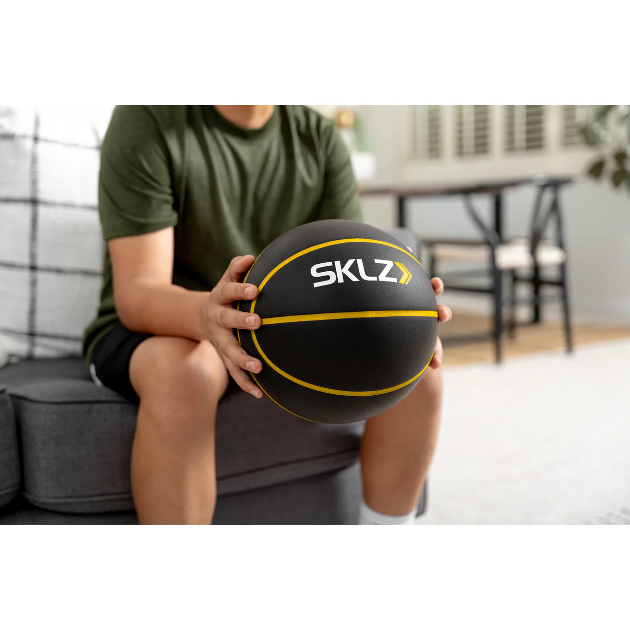 SKLZ BASHHHKETBALL PRO FES SIOC BASKETBALL - lifestyle view, person holding ball seated indoors