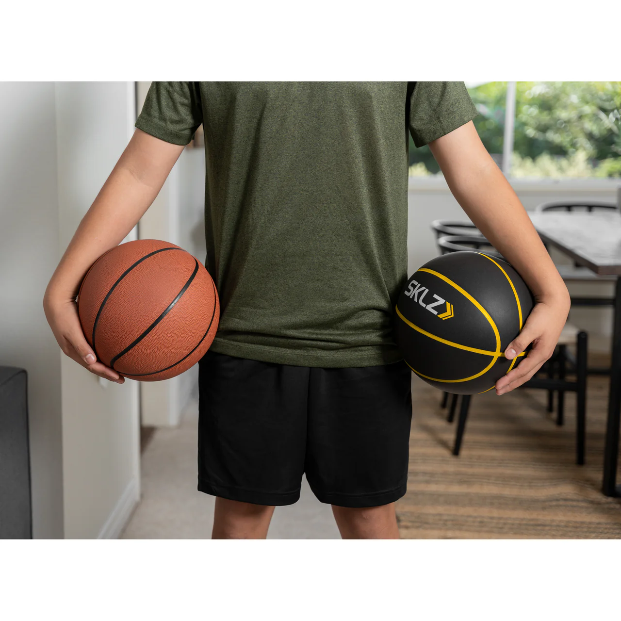 SKLZ BASHHHKETBALL PRO FES SIOC BASKETBALL - comparison with regular basketball, both held by player indoors