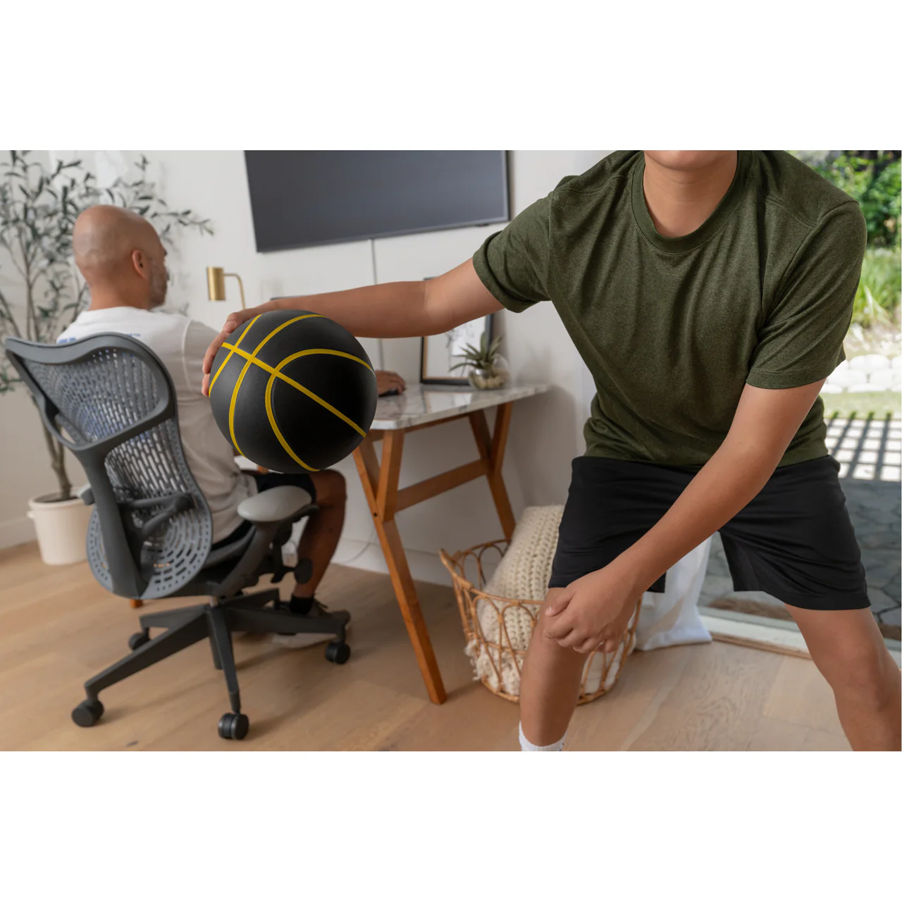 SKLZ BASHHHKETBALL PRO FES SIOC BASKETBALL - lifestyle view, player exercising with ball in home office
